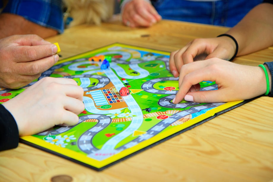 Hands of a Family Playing a Board Game